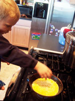 The toddler adding cheese to the omelet