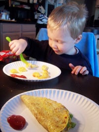 The toddler eating the egg