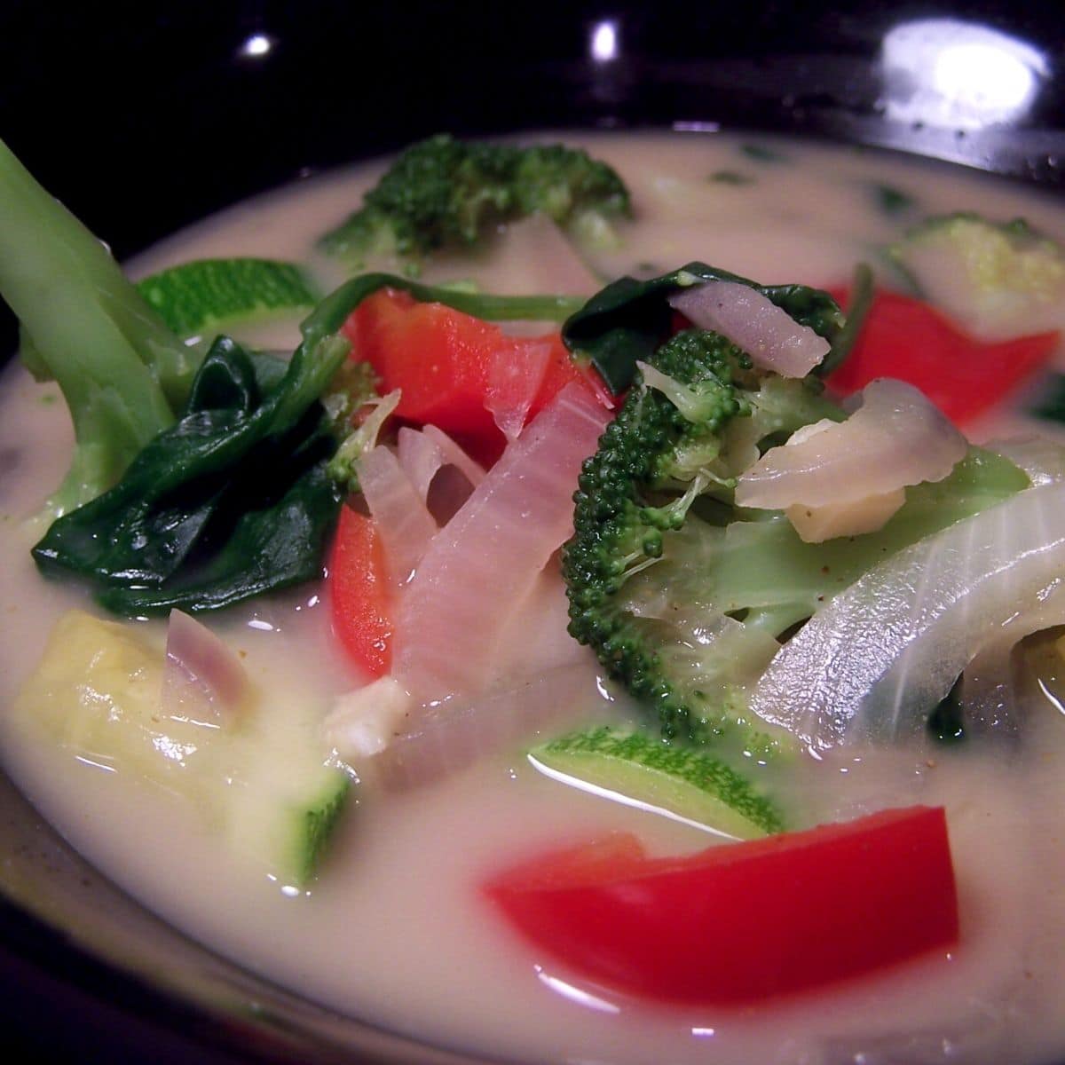 Thai vegetable soup in black bowl