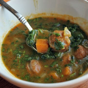 Bowl of Pumpkin and Sausage Soup with Sweet Potatoes and Spinach