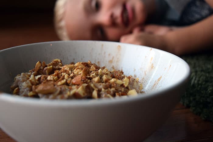 bowl of oatmeal with toddler in background. 